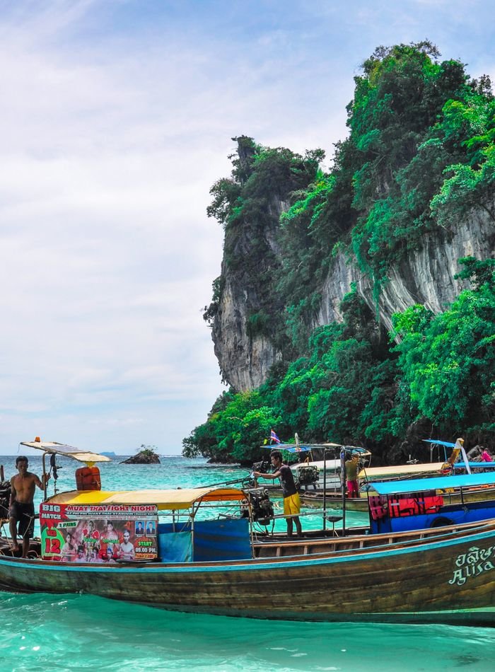 Longtail boats below limestone cliffs in Thailand